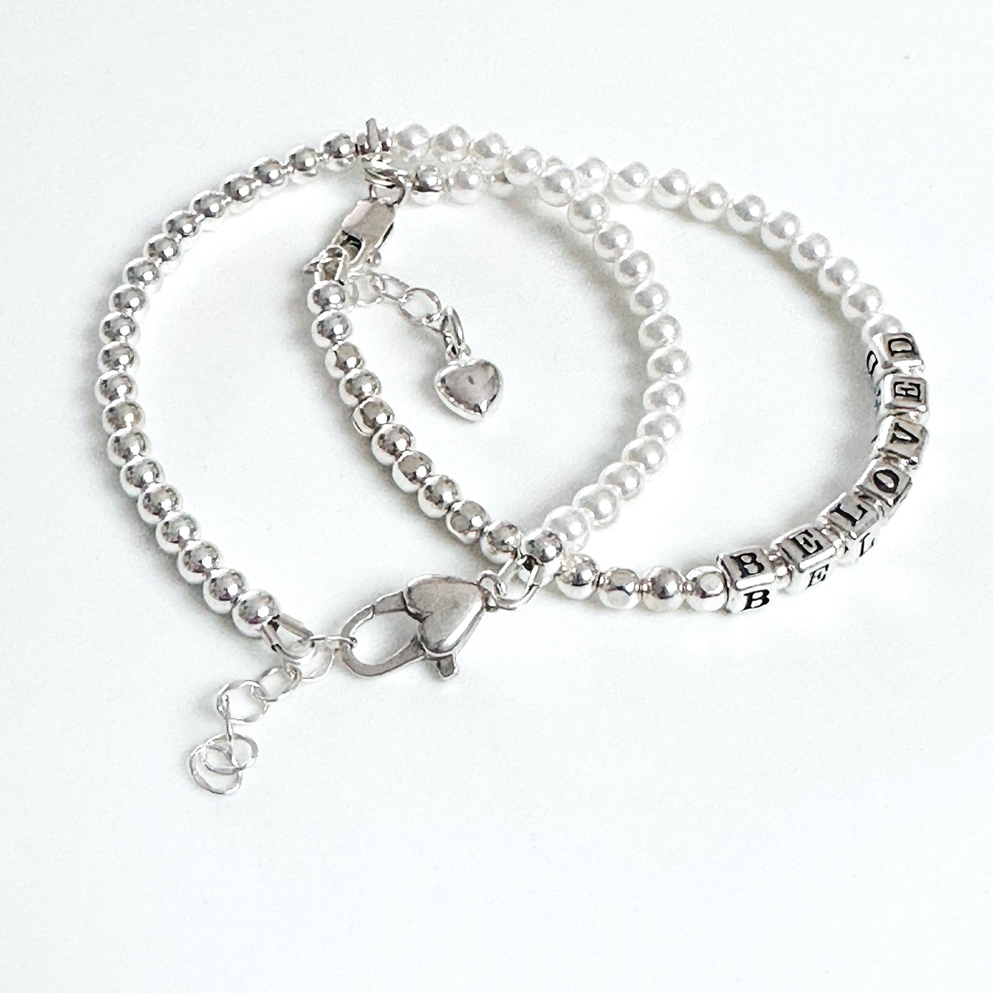 Beaded bracelet with sterling silver and pearls spelling out BELOVED, with heart charm, and additional pearl and silver bracelet