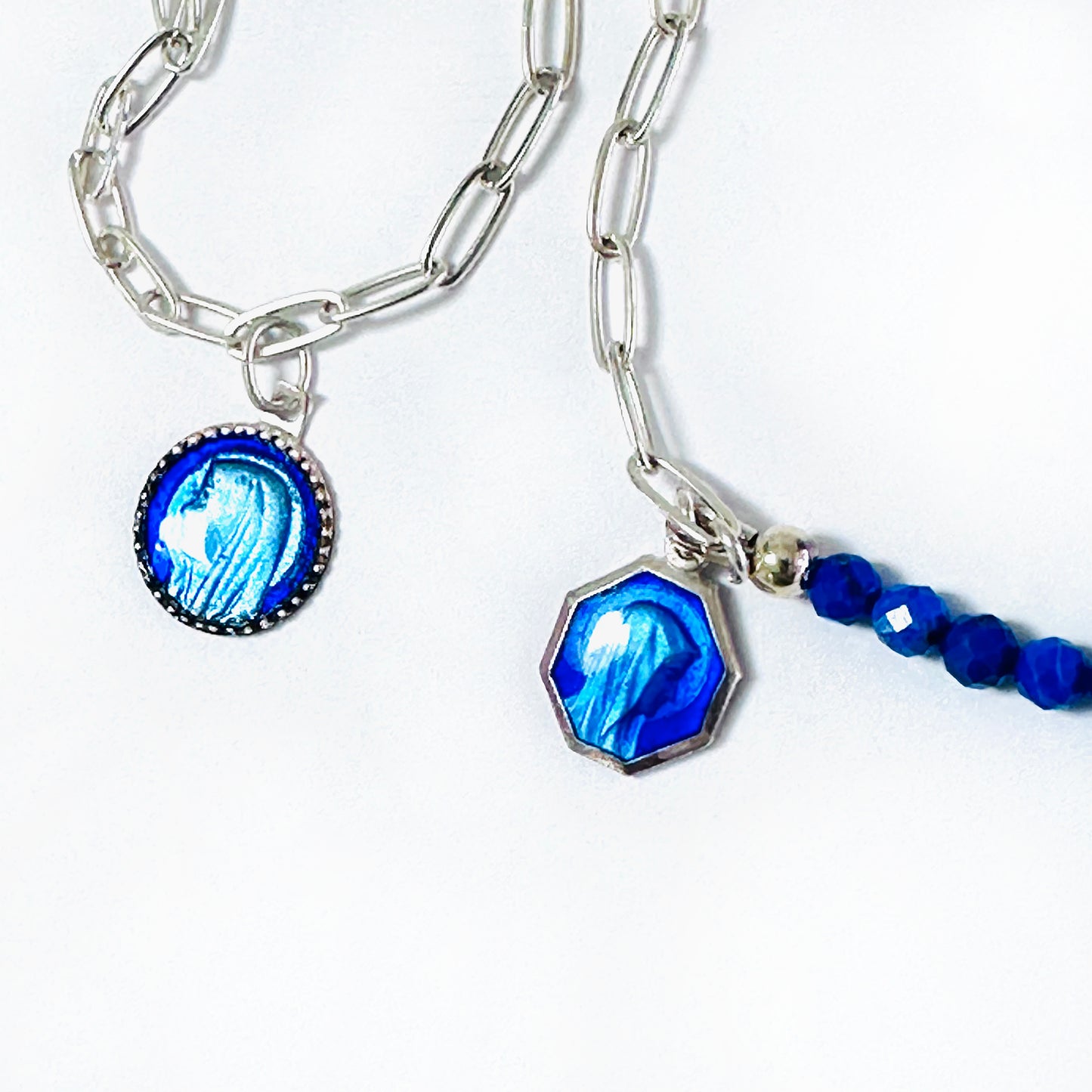 Detail of two modern Catholic jewelry bracelets, with sterling silver and blue medals of Lourdes Mother Mary