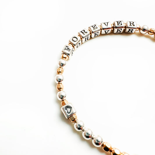 Sterling Silver and 14k Gold Hand Beaded bracelet spells out the word FOREVER
